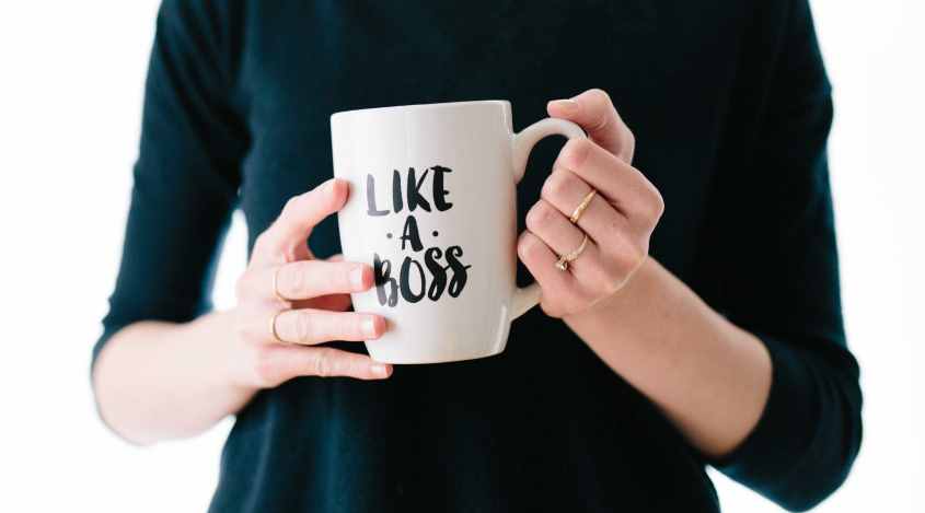Photo of woman holding a "Like a Boss" coffee mug, by Brooke Lark on Unsplash